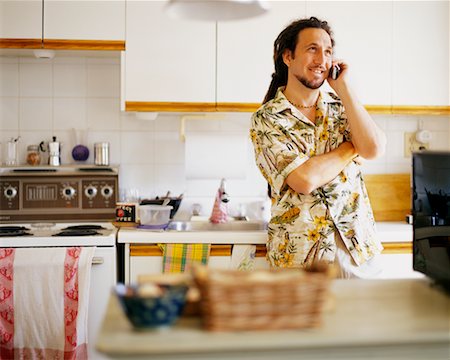 person in hawaiian shirt - Man Using Cellular Phone in Kitchen Stock Photo - Rights-Managed, Code: 700-00166262