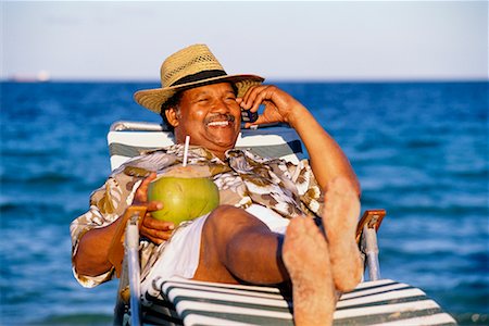 fat man sunbathing photos - Man at the Beach with Cell Phone Stock Photo - Rights-Managed, Code: 700-00160094