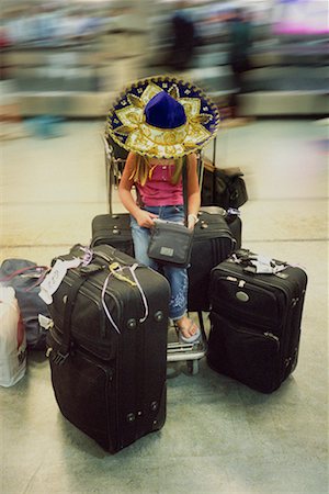 sombreiro - Girl Wearing Sombrero Sitting On Luggage Foto de stock - Direito Controlado, Número: 700-00161673