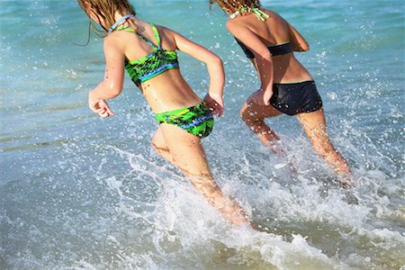 families running in surf on beach - Two Girls Running through Waves Stock Photo - Rights-Managed, Code: 700-00161716