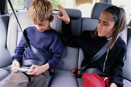 rivalidade entre irmãos - Children in Back Seat of Van Foto de stock - Direito Controlado, Número: 700-00177744