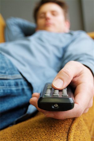 simsearch:700-01015047,k - Man Lying Down Holding Remote Control Stock Photo - Rights-Managed, Code: 700-00178029