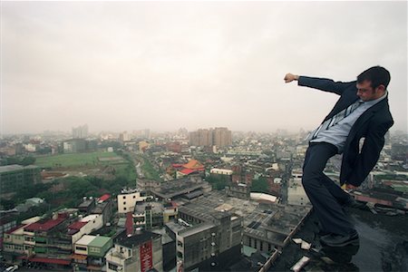 superar obstáculos - Man Standing on Edge of Building Foto de stock - Con derechos protegidos, Código: 700-00181482