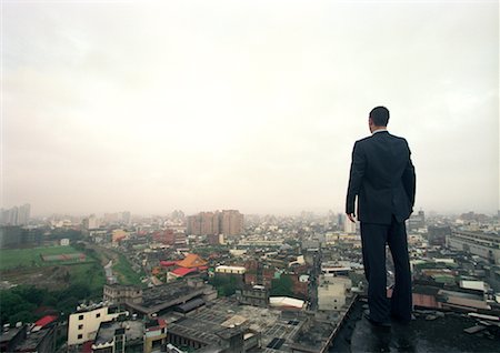 superar obstáculos - Man Standing on Edge of Building Foto de stock - Con derechos protegidos, Código: 700-00181483