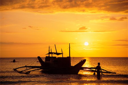 philippines outrigger canoe - Silhouette of Person and Boat At Sunset Stock Photo - Rights-Managed, Code: 700-00183716