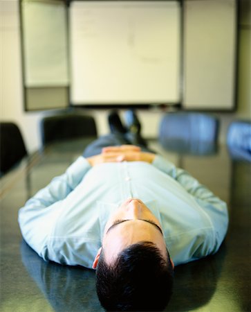 Man Lying on Boardroom Table Stock Photo - Rights-Managed, Code: 700-00183932