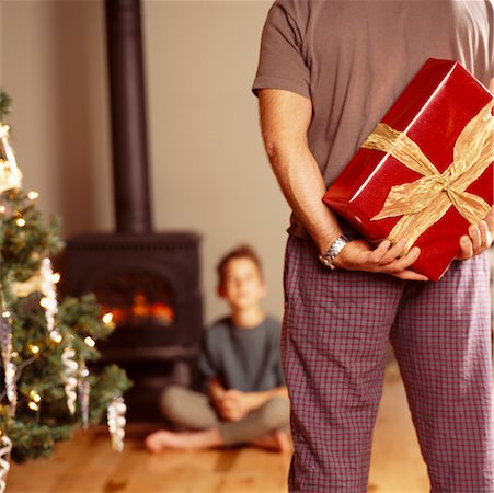 scambio dei regali di natale - Father Hiding Christmas Gift from Son Fotografie stock - Rights-Managed, Codice: 700-00195085