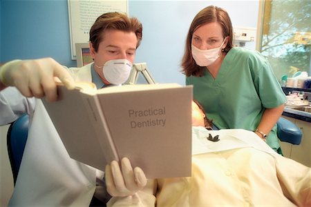 simsearch:700-01194910,k - Dentiste et assistante dentaire de lecture livre Photographie de stock - Rights-Managed, Code: 700-00195227