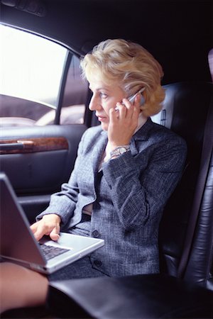 simsearch:700-00195272,k - Femme avec ordinateur portable et téléphone dans Limo Photographie de stock - Rights-Managed, Code: 700-00195270