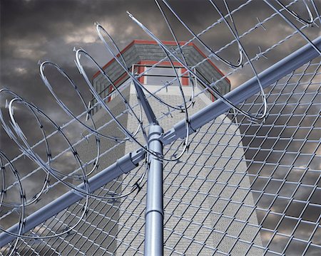 simsearch:6118-09059537,k - Prison Tower behind Barbed Wire Stock Photo - Rights-Managed, Code: 700-00197393