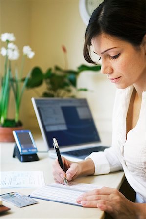 signing a check - Woman Paying Bills Stock Photo - Rights-Managed, Code: 700-00198081