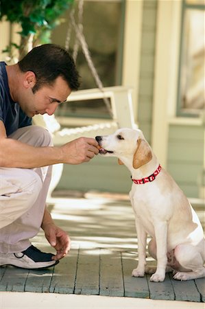 Man Feeding Dog Stock Photo - Rights-Managed, Code: 700-00198263