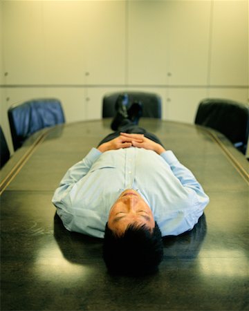 sleeping on boardroom table - Man Lying on Boardroom Table Stock Photo - Rights-Managed, Code: 700-00199171