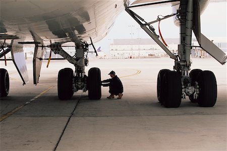 plane runway people - Aircraft Worker Checking Landing Gear Stock Photo - Rights-Managed, Code: 700-00193679