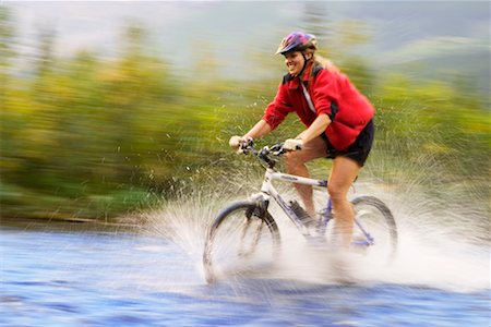 superar obstáculos - Woman Crossing River on Mountain Bike Foto de stock - Con derechos protegidos, Código: 700-00281796