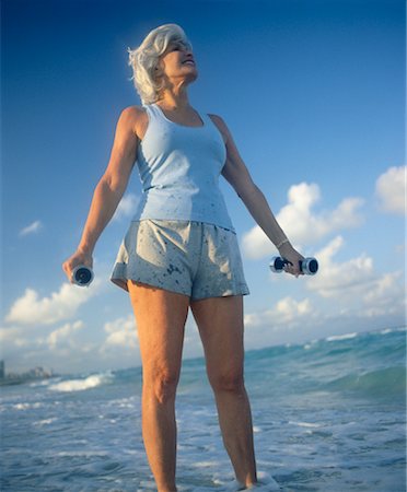 simsearch:614-02613976,k - Woman Holding Weights Standing in Surf Stock Photo - Rights-Managed, Code: 700-00329187