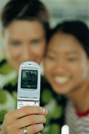 Two Women Taking Picture with Camera Phone Stock Photo - Rights-Managed, Code: 700-00345097