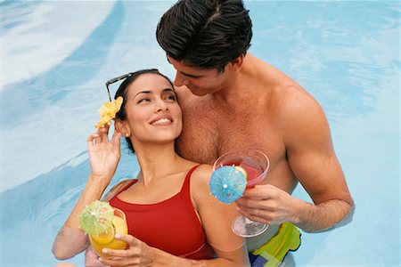 Paar im Schwimmbad hält Getränke stehen Stockbilder - Lizenzpflichtiges, Bildnummer: 700-00357425