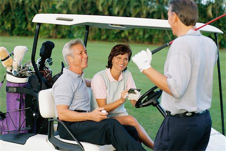 Couple in Golf Cart, Talking to Friend Foto de stock - Direito Controlado, Número: 700-00357744