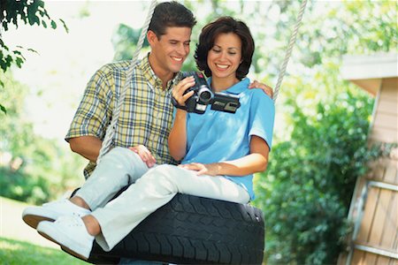 simsearch:700-00037048,k - Couple avec caméra vidéo sur pneu Swing Photographie de stock - Rights-Managed, Code: 700-00350218