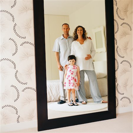 family portraits in frames - Famille reflétée dans le miroir de chambre à coucher Photographie de stock - Rights-Managed, Code: 700-00363662