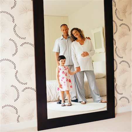 family portraits in frames - Famille reflétée dans le miroir de chambre à coucher Photographie de stock - Rights-Managed, Code: 700-00363663