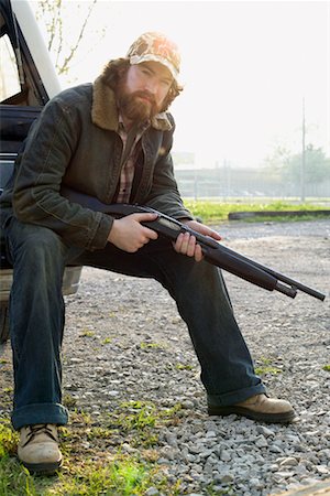 redneck facial hair - Portrait d'un homme assis avec pistolet Photographie de stock - Rights-Managed, Code: 700-00404157