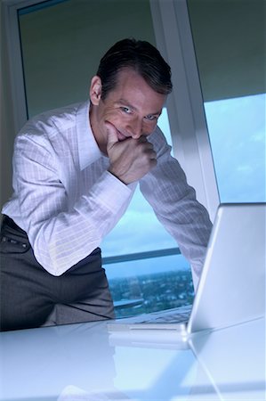 sneaky businessman laptop - Homme à l'aide d'ordinateur portable Photographie de stock - Rights-Managed, Code: 700-00458204