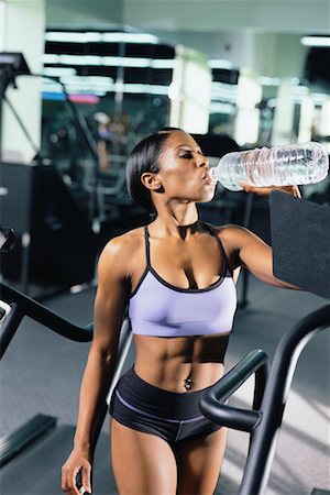 satisfied (thirst) - Woman on Treadmill, Drinking Water Foto de stock - Con derechos protegidos, Código: 700-00459906