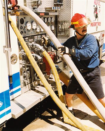 simsearch:640-03262178,k - Firefighter Monitoring Hoses and Gauges on Fire Truck Stock Photo - Rights-Managed, Code: 700-00453247