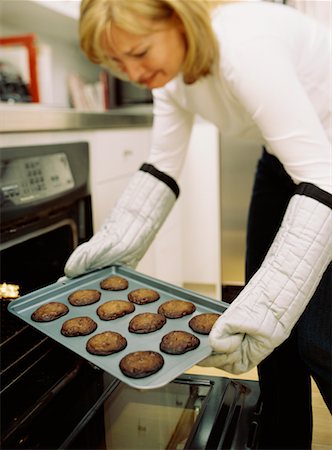 simsearch:700-01787509,k - Woman Removing Cookies from Oven Foto de stock - Direito Controlado, Número: 700-00478210