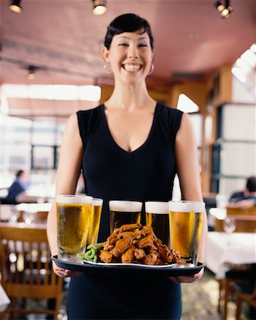 Serveuse transportant de la bière et ailes de poulet sur le plateau Photographie de stock - Rights-Managed, Code: 700-00478249