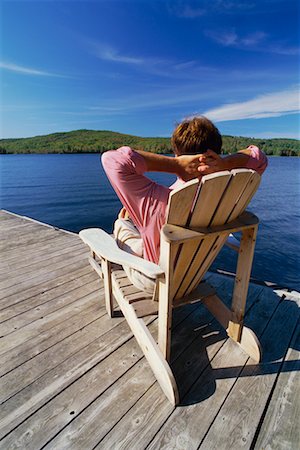 Man Relaxing in Adirondack Chair On Dock Stock Photo - Rights-Managed, Code: 700-00481983