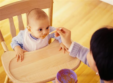 photo of mother feeding baby high chair - Mother Feeding Baby Stock Photo - Rights-Managed, Code: 700-00517755