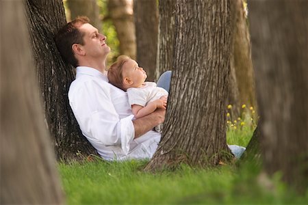 father holding son in lap - Father and Baby Sitting Under a Tree Stock Photo - Rights-Managed, Code: 700-00524445