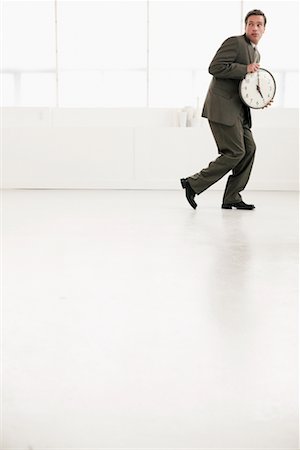 Businessman Leaving with Clock Stock Photo - Rights-Managed, Code: 700-00524481