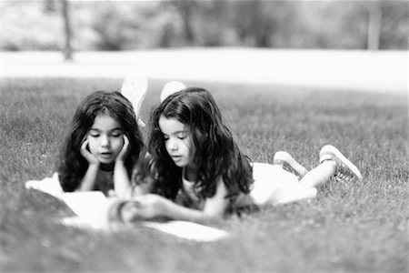 Twin Sisters Reading on Grass Fotografie stock - Rights-Managed, Codice: 700-00528019