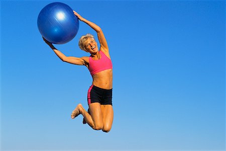 Woman Jumping In Air With Exercise Ball Stock Photo - Rights-Managed, Code: 700-00528183