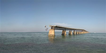 Man Riding Bicycle off End of Bridge Foto de stock - Con derechos protegidos, Código: 700-00528387