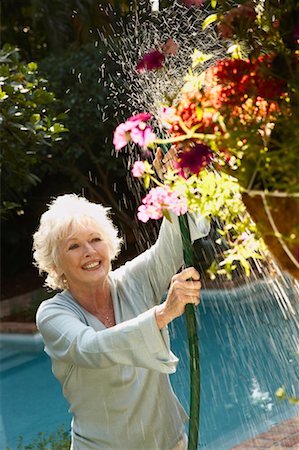 spraying water hose - Woman Watering Plants Stock Photo - Rights-Managed, Code: 700-00528836
