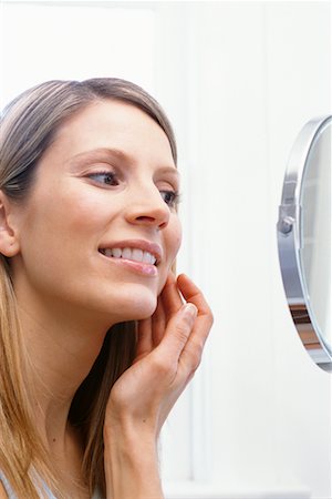 Woman Looking in Bathroom Mirror Stock Photo - Rights-Managed, Code: 700-00528872