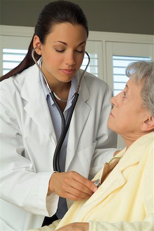 Doctor Listening to Woman's Heart Foto de stock - Con derechos protegidos, Código: 700-00520275