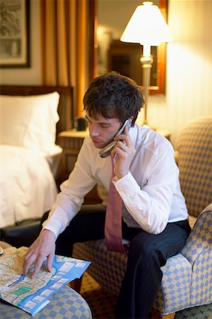 Businessman with Cellular Phone And Map in Hotel Room Stock Photo - Rights-Managed, Code: 700-00520323