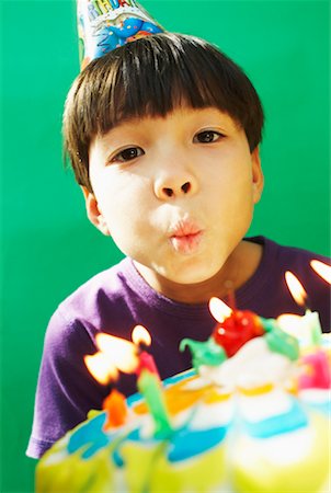 Boy Blowing Out Candles on Birthday Cake Stock Photo - Rights-Managed, Code: 700-00520552