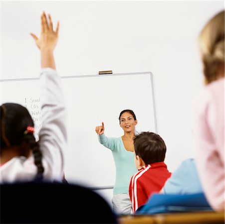 students with hands raised in classroom with female teacher - Teacher Calling on Student in Classroom Stock Photo - Rights-Managed, Code: 700-00523355