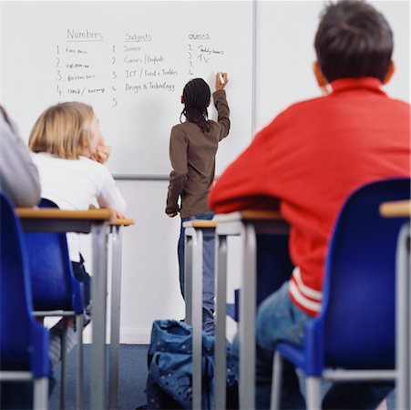 school boy standing and looking up - Student Writing On Whiteboard In Classroom Stock Photo - Rights-Managed, Code: 700-00523380