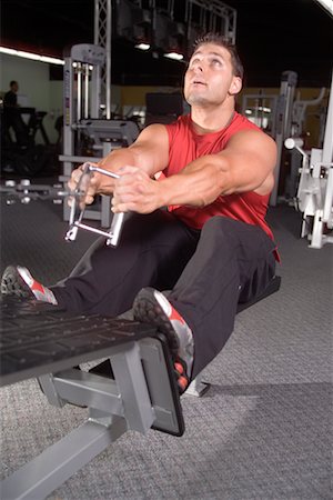 simsearch:700-00530584,k - Homme à l'aide de poids Machine dans une salle de sport Photographie de stock - Rights-Managed, Code: 700-00530568