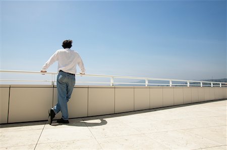 person leaning on rail with back - Man Looking Over Balcony Stock Photo - Rights-Managed, Code: 700-00546286