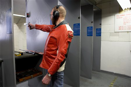 protector de oídos - Man Shooting Handgun in Firing Booth Foto de stock - Con derechos protegidos, Código: 700-00546350