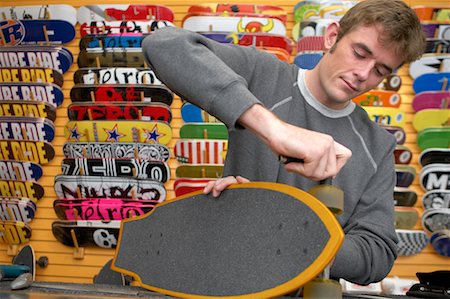 simsearch:700-03404747,k - Man Adjusting Wheel on Skateboard Foto de stock - Con derechos protegidos, Código: 700-00546743